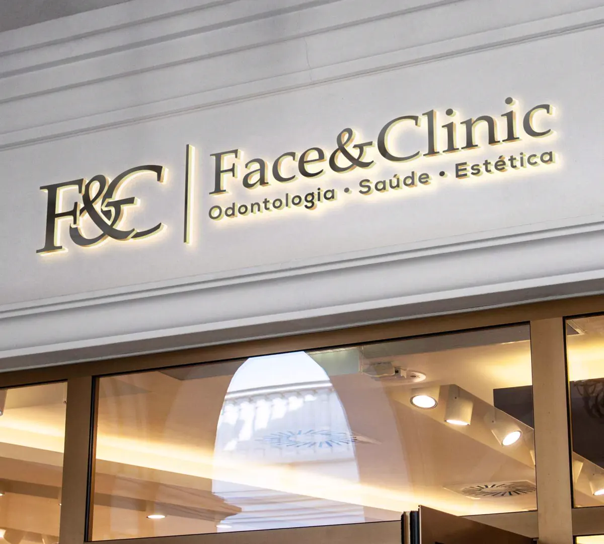 Fachada da Face&Clinic com o logotipo em letras iluminadas: Odontologia, Saúde e Estética